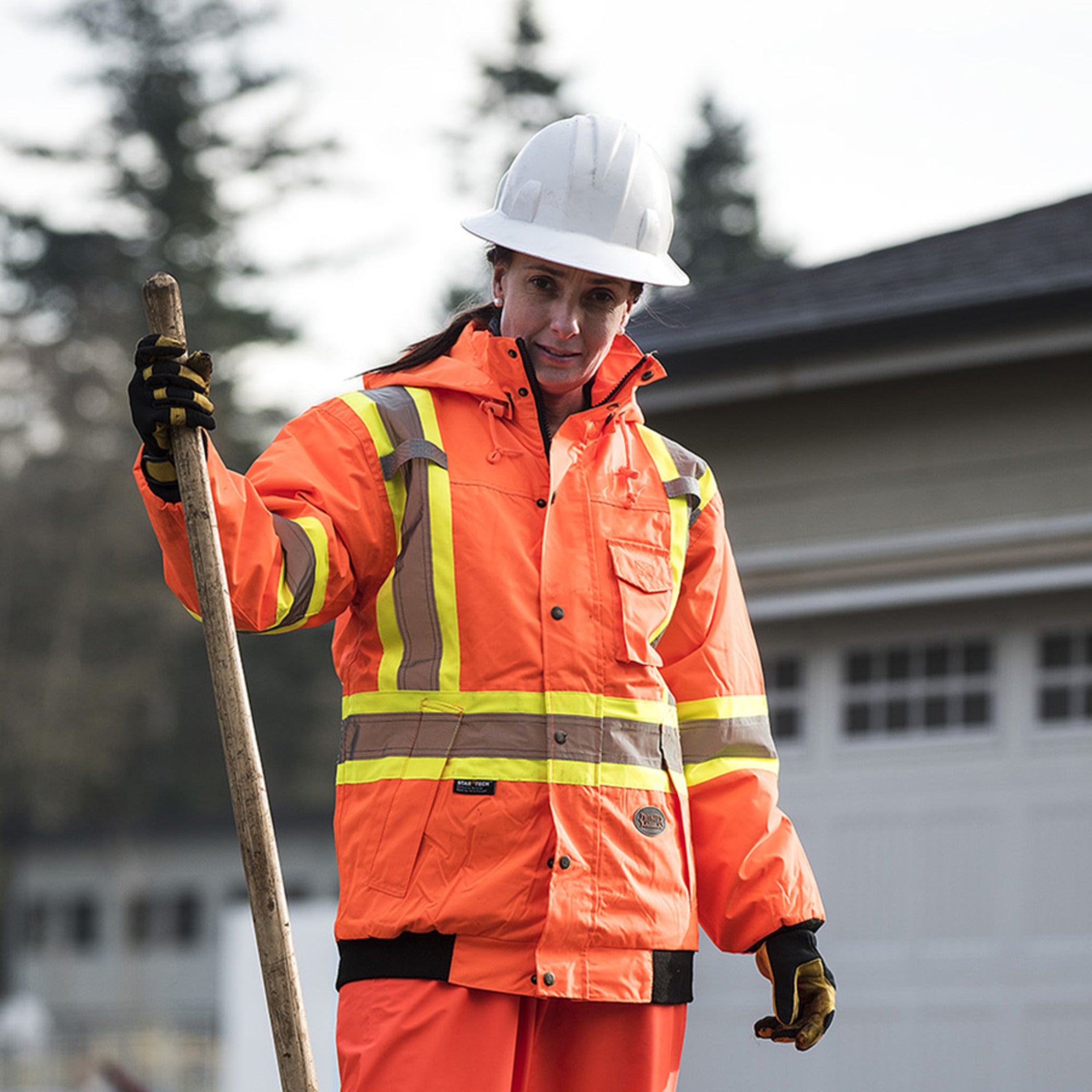 Worker wearing hi vis winter work bomber jacket on outdoor jobsite