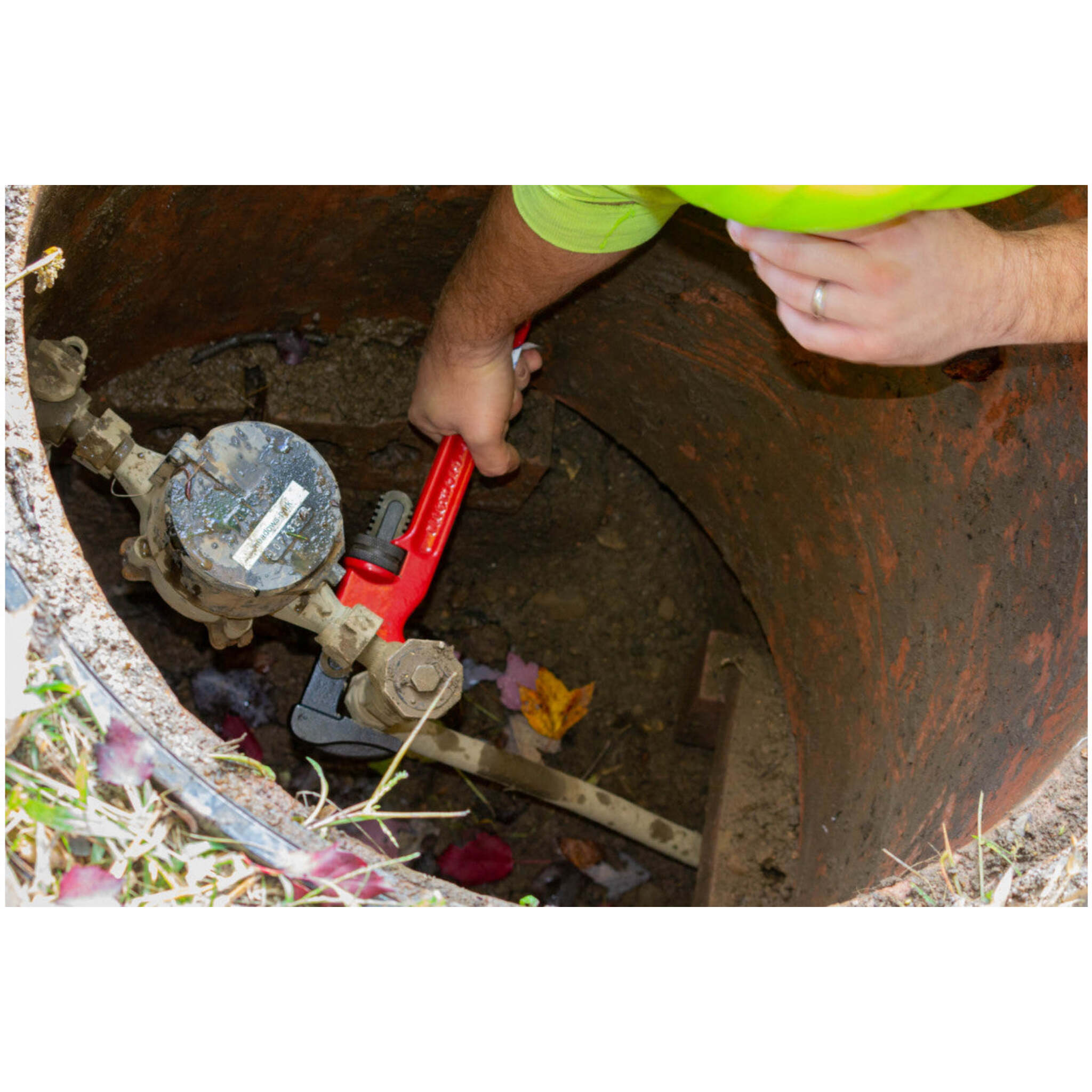 Plumber adjusting water meter valve