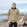 Man wearing Stanfield's 1328 heritage heavy weight wool henley in khaki with a toque on a rocky shoreline